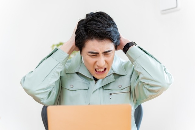 頭を抱えて悩む男性