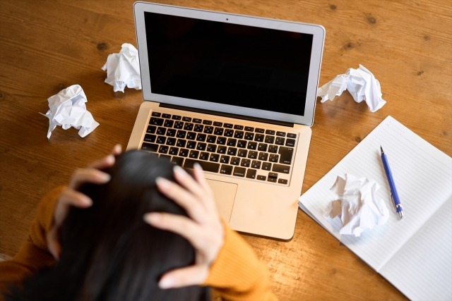 頭を抱えて悩む女性